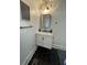 Updated half bathroom featuring a modern vanity with marble countertop and stylish black hardware and decor at 535 Walnut St, Hapeville, GA 30354