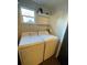 Functional laundry area featuring a washer, a dryer, and convenient shelving for storage at 535 Walnut St, Hapeville, GA 30354