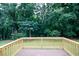The back deck has a stained wood floor and railing, overlooking the private backyard at 555 Flintlock Dr, Dacula, GA 30019