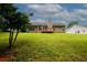 A view of the grassy backyard and rear exterior elevation of the home at 555 Flintlock Dr, Dacula, GA 30019