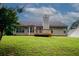 Rear elevation of the home with access to a backyard deck at 555 Flintlock Dr, Dacula, GA 30019