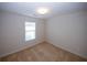 Cozy bedroom with a neutral color scheme, carpeted floor, and a window for natural light at 555 Flintlock Dr, Dacula, GA 30019