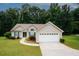 Lovely home with attached two-car garage and green shutters surrounded by mature trees at 555 Flintlock Dr, Dacula, GA 30019