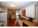 Features of this kitchen include white cabinets and a double sink, with a view into the home's entryway at 555 Flintlock Dr, Dacula, GA 30019