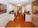 Bright kitchen featuring wood floors, white cabinets, and modern appliances with an open view into the living room at 555 Flintlock Dr, Dacula, GA 30019