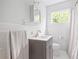 Bright bathroom featuring a gray vanity cabinet, white subway tile, and neutral walls at 138 Woodlawn Ave, Decatur, GA 30030