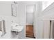 Cozy bathroom featuring a pedestal sink, white tile walls, and hardwood floors at 138 Woodlawn Ave, Decatur, GA 30030
