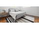 Stylishly staged bedroom with gray upholstered bed frame, modern rug, and hardwood floors at 138 Woodlawn Ave, Decatur, GA 30030