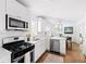 Bright kitchen features white cabinets, stainless steel appliances, and hardwood floors with view to a dining area at 138 Woodlawn Ave, Decatur, GA 30030