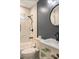 Stylish bathroom featuring marble tile shower, a modern round mirror, and a white vanity with black fixtures at 205 Maple St, Atlanta, GA 30354