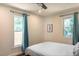 Bright bedroom with blue curtains, two windows, hardwood floors and a bed with striped bedding at 205 Maple St, Atlanta, GA 30354