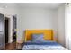 Cozy bedroom with hardwood flooring, a modern yellow headboard, and blue striped bedding at 205 Maple St, Atlanta, GA 30354
