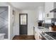 Well-lit kitchen includes stainless steel appliances, quartz countertops, white cabinetry and a laundry area at 205 Maple St, Atlanta, GA 30354