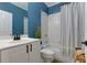 Inviting bathroom featuring blue accent wall, shower and white vanity at 4825 Whispering Pine Way, Cumming, GA 30028