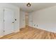This bedroom features hardwood floors, white walls, a light fixture and a closet at 4825 Whispering Pine Way, Cumming, GA 30028