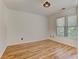 Clean and bright bedroom with hardwood floors and natural light from the window at 4825 Whispering Pine Way, Cumming, GA 30028