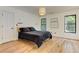 Modern bedroom with dark bedding, two large windows, and hardwood floors at 4825 Whispering Pine Way, Cumming, GA 30028
