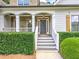 Close-up of front entrance featuring brick accents, covered porch, and meticulously landscaped greenery at 4825 Whispering Pine Way, Cumming, GA 30028