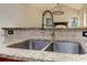 Close-up of kitchen sink, granite countertop, and tiled backsplash at 4825 Whispering Pine Way, Cumming, GA 30028