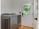 Convenient laundry room with modern washer and dryer and a glass door at 4825 Whispering Pine Way, Cumming, GA 30028