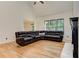 Living room with vaulted ceiling, hardwood floors, and leather sectional at 4825 Whispering Pine Way, Cumming, GA 30028