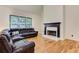 Bright living room with hardwood floors, fireplace, and leather sectional at 4825 Whispering Pine Way, Cumming, GA 30028