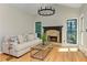 Cozy living room with fireplace, hardwood floors, and natural light at 4825 Whispering Pine Way, Cumming, GA 30028