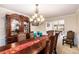 Formal dining room featuring elegant wood table, upholstered chairs, display cabinet, and decorative chandelier at 11961 Markham Way, Hampton, GA 30228