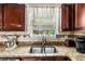 Granite countertop kitchen with stainless steel sink, modern appliances, and decorative backsplash at 11961 Markham Way, Hampton, GA 30228