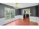 Dining room featuring dark accent wall, hardwood floors, and decorative chandelier at 1553 Smithson Ct, Lithonia, GA 30058