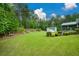 Expansive backyard featuring lush green grass, a greenhouse, and mature trees at 188 A Macedonia Rd, White, GA 30184