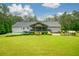 A spacious yard showcasing the home's expansive deck, a pool, an outdoor seating area, and beautiful landscaping at 188 A Macedonia Rd, White, GA 30184