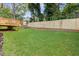Lush green backyard with a wooden fence and small wooden deck, perfect for outdoor relaxation at 3155 Zion St, Scottdale, GA 30079