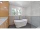 Bright bathroom with a freestanding tub, gray tiled accent wall, and double windows at 3155 Zion St, Scottdale, GA 30079