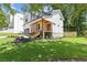 Side angle view of the home showing the porch, landscaped yard, and lush surrounding greenery at 3155 Zion St, Scottdale, GA 30079