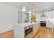 Bright kitchen features an island with a marble countertop, stainless steel appliances, and light fixtures at 3155 Zion St, Scottdale, GA 30079