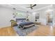 Spacious main bedroom featuring hardwood floors, ceiling fan, modern lighting, and a window at 3155 Zion St, Scottdale, GA 30079