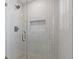 Modern shower featuring stylish vertical tiles, hexagon floor, glass door, and recessed shelf at 3155 Zion St, Scottdale, GA 30079