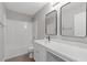 Modern bathroom with sleek fixtures, a shower-tub combo, and double mirrors over a white countertop at 4420 Ambassador Way, Cumming, GA 30040