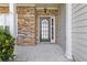 Close-up of the inviting front door with decorative glass and stone detailing on the facade at 4420 Ambassador Way, Cumming, GA 30040