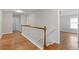 Bright hallway with hardwood floors and a wooden railing staircase for a modern look at 4420 Ambassador Way, Cumming, GA 30040