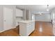 Kitchen area features a central island, wood floors, and white cabinets at 4420 Ambassador Way, Cumming, GA 30040