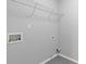 This laundry room has gray walls, tile floors, and a wire rack shelf for optimal organization at 4420 Ambassador Way, Cumming, GA 30040