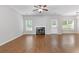 Bright living room featuring a fireplace, ceiling fan, and wood-look flooring at 4420 Ambassador Way, Cumming, GA 30040