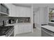 Contemporary kitchen boasts white cabinets, sleek appliances, and stylish gray backsplash at 1667 Sylvan Sw Rd, Atlanta, GA 30310
