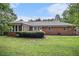 Expansive backyard with a well-manicured lawn, mature landscaping, and a brick home exterior providing a peaceful retreat at 3003 Hanover Se Ln, Conyers, GA 30094