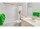 Bright bathroom with white tiled shower and tub combination, complemented by a sink with a cream-colored vanity at 3003 Hanover Se Ln, Conyers, GA 30094
