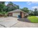Detached garage with an asphalt driveway, well-manicured landscaping, and mature trees, all beneath a clear blue sky at 3003 Hanover Se Ln, Conyers, GA 30094