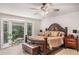 Cozy main bedroom with a large window, ceiling fan, and bench at 3003 Hanover Se Ln, Conyers, GA 30094