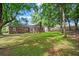 A sprawling backyard featuring a well-maintained lawn, mature trees, and a brick house at 365 Norcross St, Roswell, GA 30075